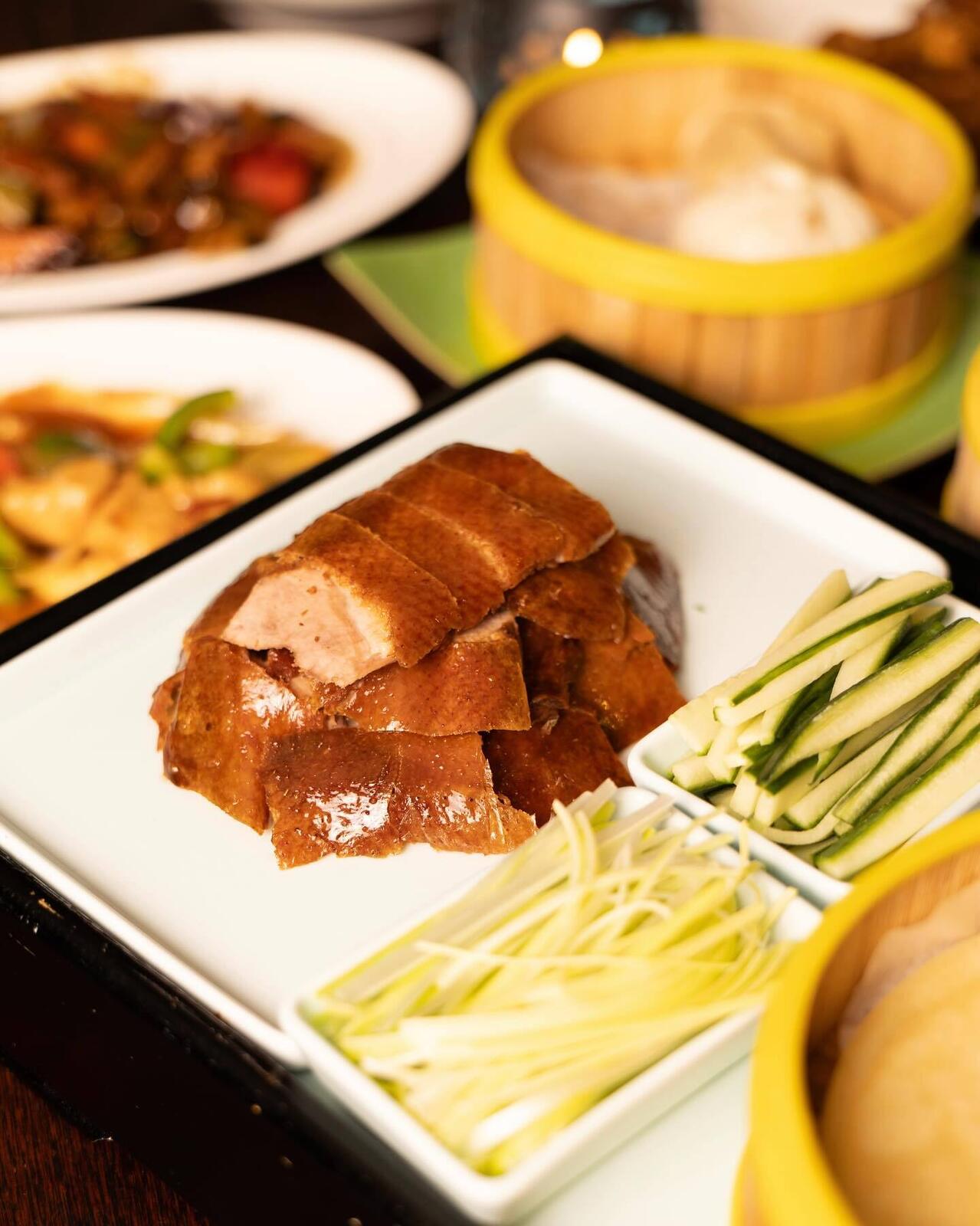 Pekingand med pannekaker og grønnsaker på bordet