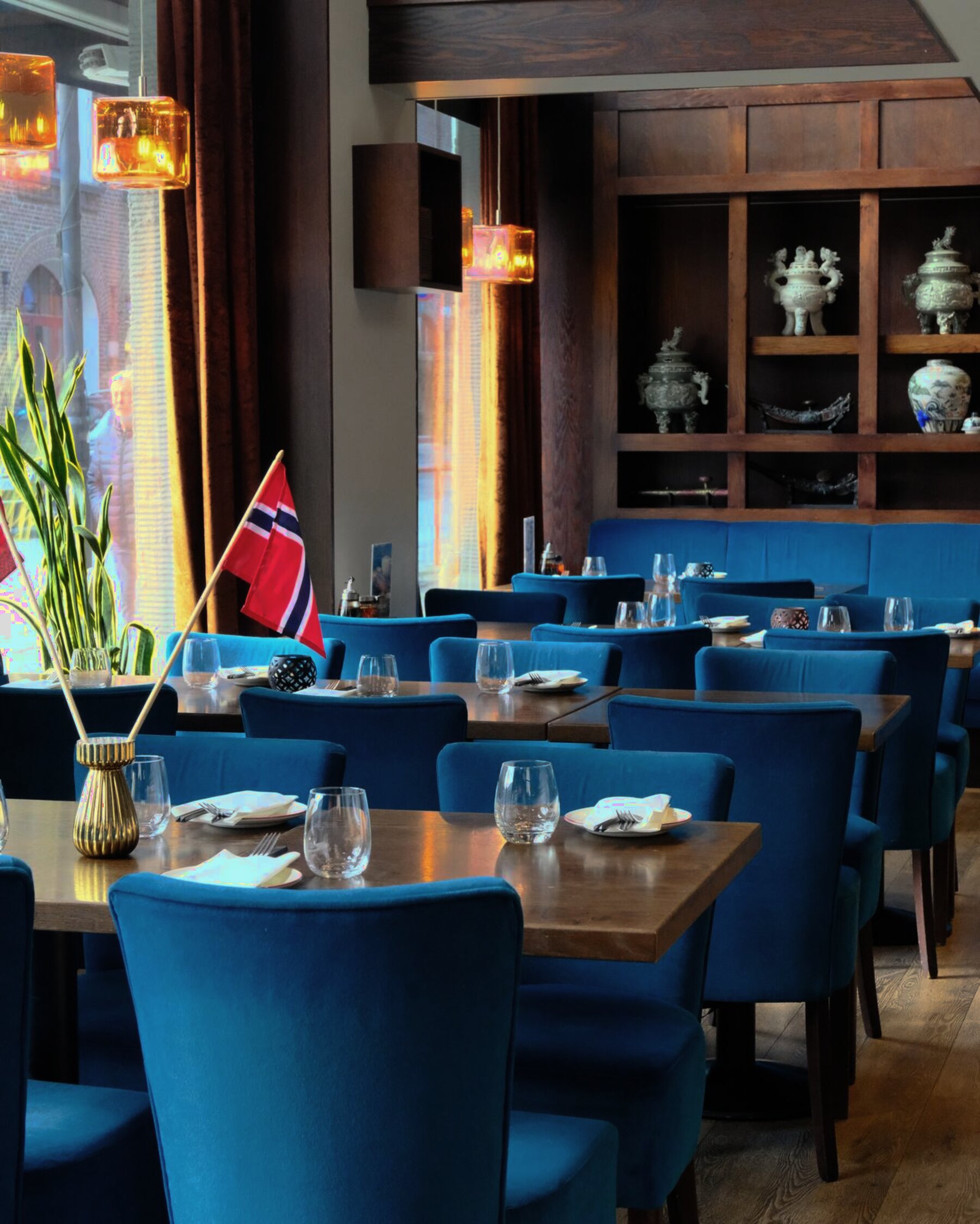 Dekkede bord med blå fløyelsstoler og varmt lys i Soya Restaurant