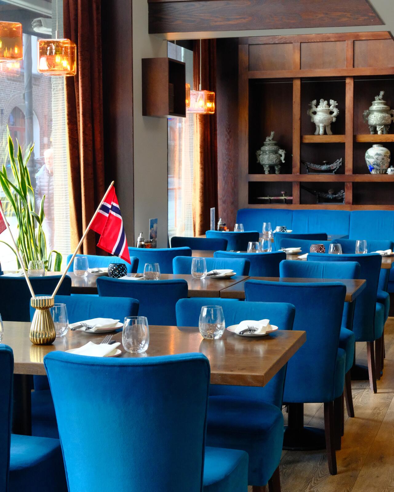 Blå fløyelsstoler og dekkede bord hos Soya Restaurant